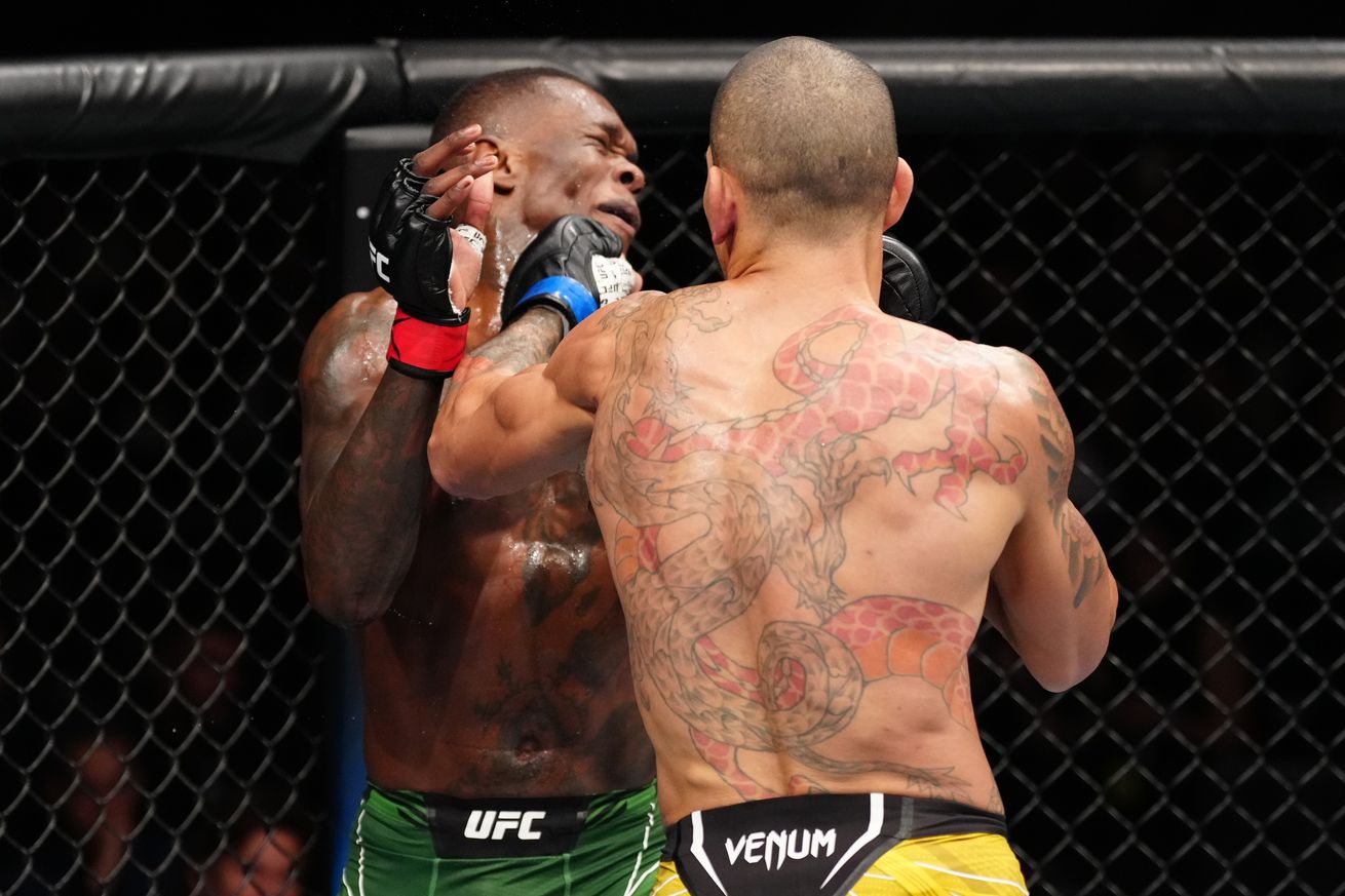 Israel Adesanya eats a left hook from Alex Pereira at UFC 281.