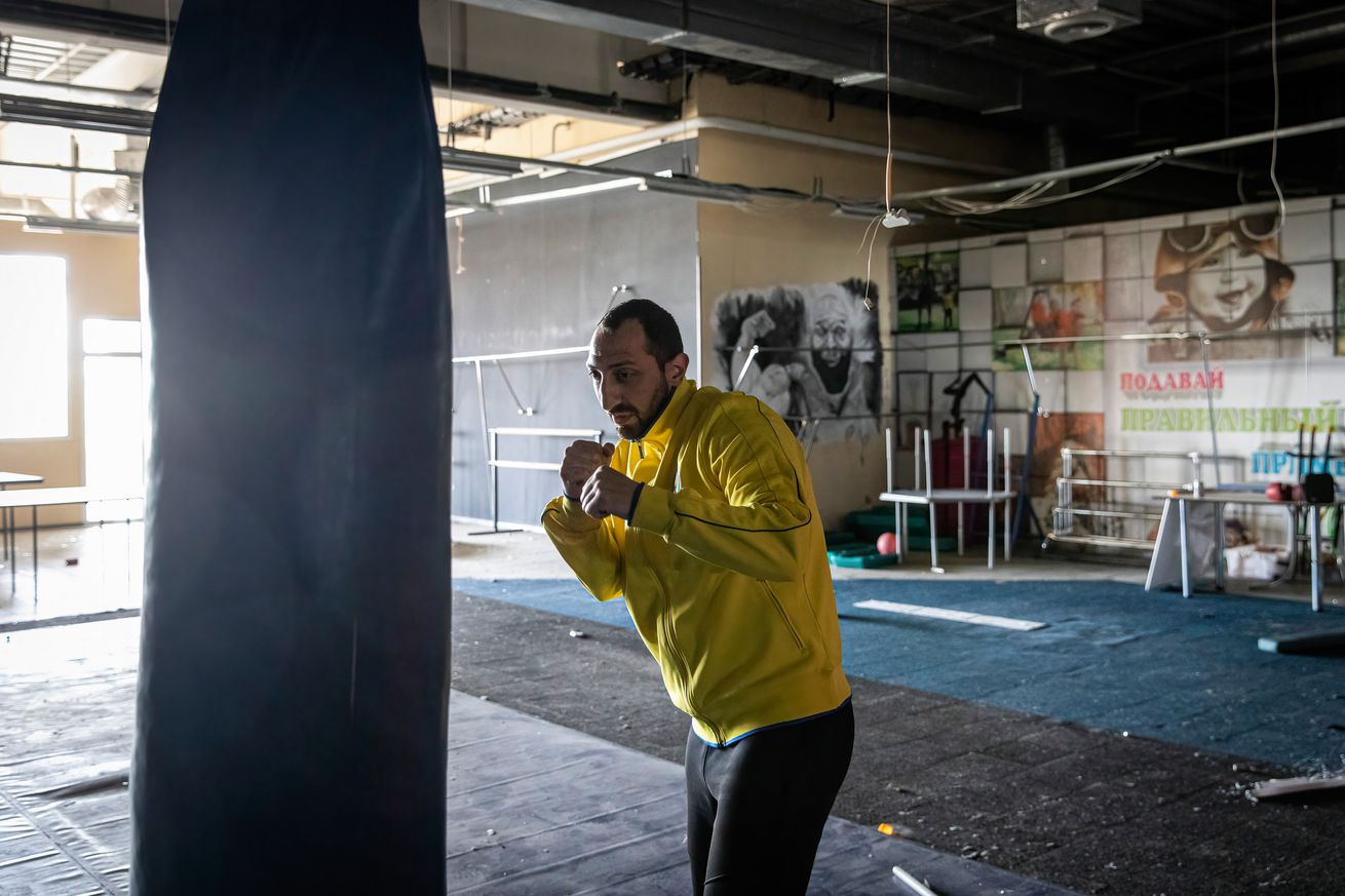 A man exercises boxing in a destroyed gym in southeastern...