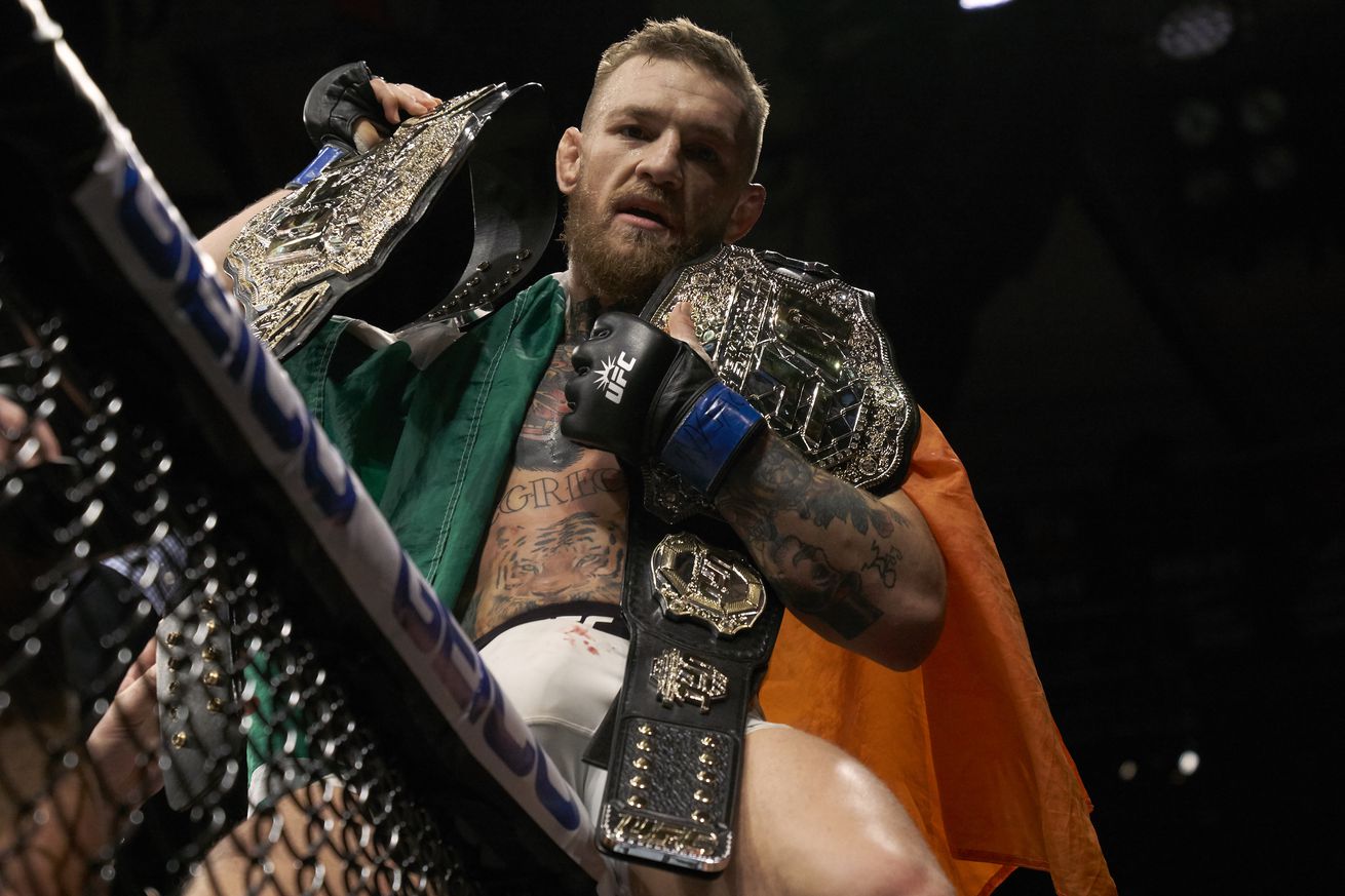 Conor McGregor hoisting two belts at UFC 205.